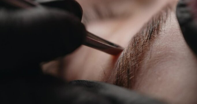 Beauty procedure: cosmetologist does eyebrow plucking, eyebrow correction in the beauty salon, 4k Prores