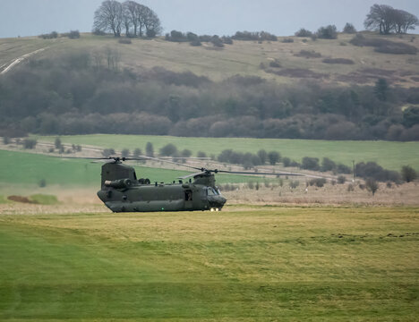 RAF Chinook CH-47 HC6A helicopter preparing to takeoff from a green grass field, in action on a military exercise, Wiltshire UK
