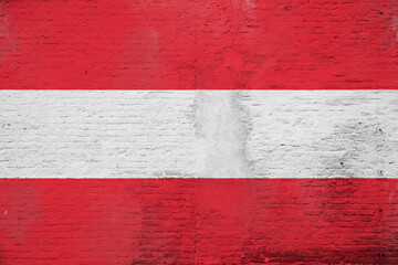 Full frame photo of a weathered flag of Austria painted on a plastered brick wall.