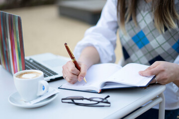 close up of a young woman writing on a notebook