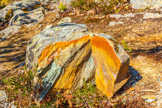 Stone rock split broken with orange yellow colors inside Norway.
