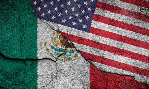 Full frame photo of weathered flags of Mexico and the United States (USA, US, America) painted on a cracked wall.