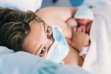 Mother breastfeeding infant in hospital during pandemic