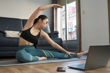 Young asian woman doing the revolved head to knee pose at home. Yoga time.