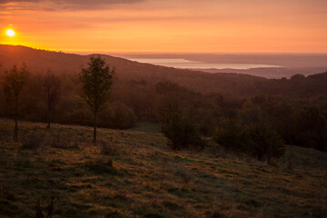 sunrise in the mountains with orange sky with a view on lake garda