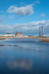 Gorleston-on-sea in Norfolk, UK. A flooded beach with cloudy reflections and views of hotel and...