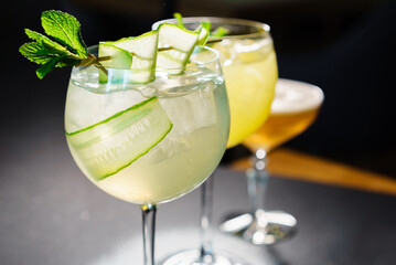 Glasses of cocktails on bar background