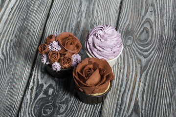 Cupcakes with cream and mascarpone. On pine boards. Close-up.