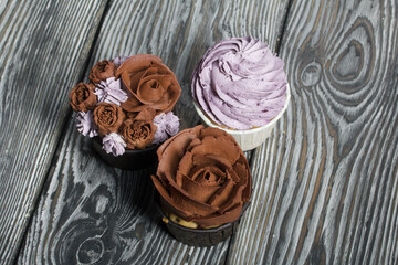 Cupcakes with cream and mascarpone. On pine boards. Close-up.