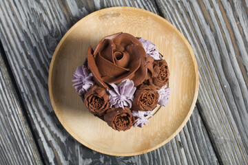 Cupcakes with cream and mascarpone. They lie on a wooden saucer. On pine boards. Close-up.