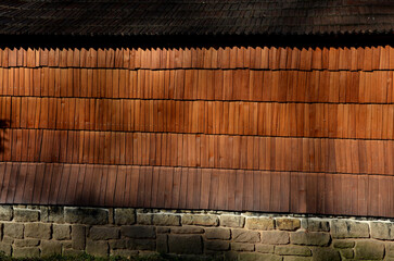 wooden paneling sphere tower shape on viking in carpathian style church. walls and roof truss made of chipped shingle tiles. half of the whole logs similar to a log cabin