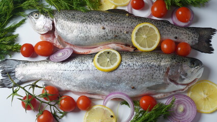 Fresh trout on a table with lemon, pepper and dill. Tasty fish ready for cooking. Healthy seafood and dieting concept.