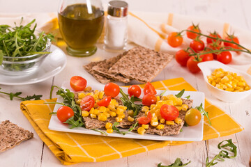 crispy rye bread with sesame seeds, arugula and sweet corn.