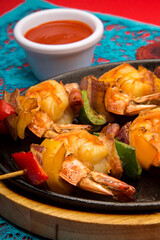 Gourmet shrimp skewers with green, red and yellow bell peppers