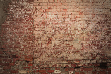 The wall is made of old weathered red brick of an ancient building. Stone texture