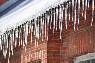 Ice icicles under the roof of the house