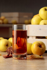 Fresh juicy apples in in wooden box and glass of apple juice.