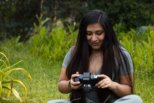 
La mujer es una fotógrafa profesional con cámara seleccionando fotos,naturaleza,
