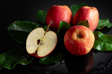 Fresh apples with drops of water on a black background.