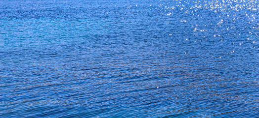 Fototapeta na wymiar Blue sea in sunshine glow as surface background. Summer holidays concept