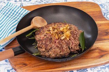 minced steak cooked in a pan on a wooden board