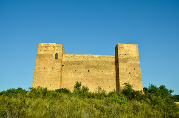 The castillo de forna on a big rock surrounded by green trees and bushes under blue sky