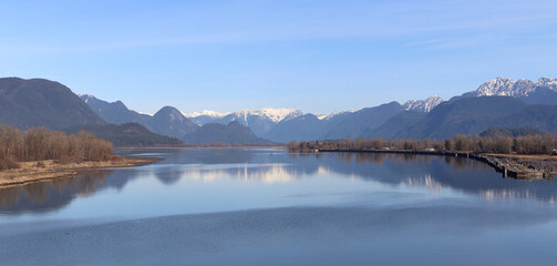Peaceful river reflecting snow-capped mountains