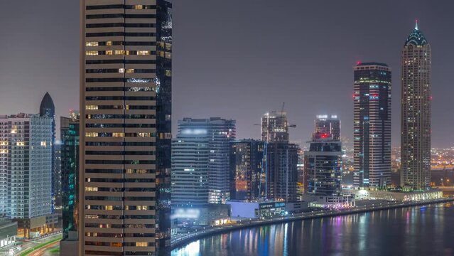 Cityscape of skyscrapers in Dubai Business Bay with water canal aerial night timelapse