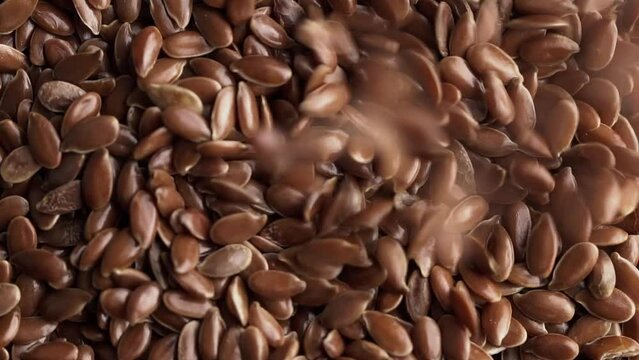 Flax seeds pouring in slow motion, macro shot.