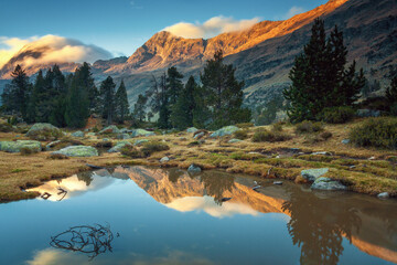 Lake formed by rain in the Benasque valley, with reflections of the mountains at sunset, Pyrenees Huesca, Spain