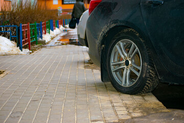 a car that drove onto the sidewalk. parking on the sidewalk. violation of parking rules. close-up. selective focus