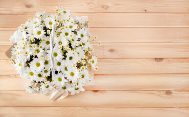 Fototapeta premium Beautiful composition of summer daisies in a festive wicker basket for a birthday or anniversary, national women's day, March 8, mother's day.