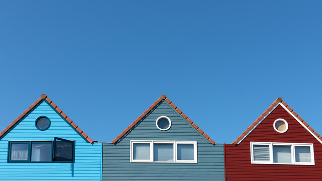 Picturesque facades of multi-colored houses against the background of a blue cloudless sky
