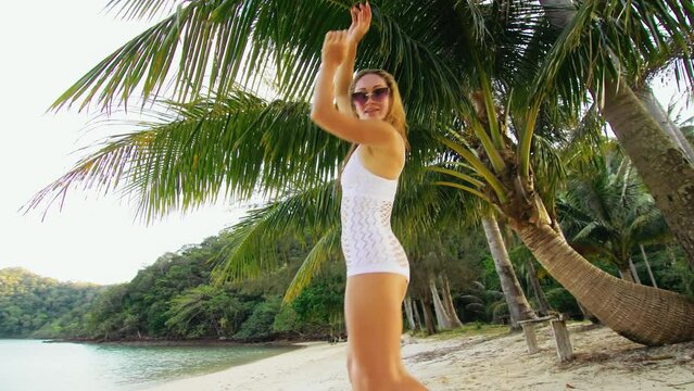 The chic girl dances an burning erotic dance in white dress in grid. The woman is having fun on an island vacation. Booty breast dancing twerk booty shake. Livestyle handheld shooting.
