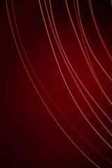 An abstract red background with a light spot in the center. Routes of movement of the light object. Lines from the lamp at a long shutter speed