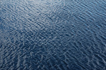 Abstract background of river water flow under the influence of light. The texture of the water