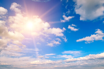 Blue sky, sun and Cumulus clouds.