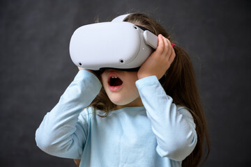 Kid using virtual reality headset, surprised child looking in VR glasses