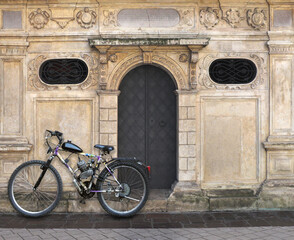 Fototapeta na wymiar A moped based on a historic building, decorative walls, iron doors, two windows, the city of Krakow Poland ...