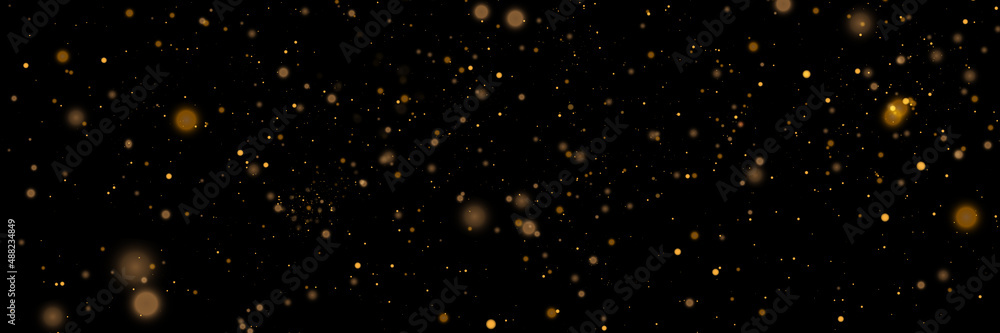 Poster glowing light effect in yellow gold color with lots of shiny particles isolated on dark background. 