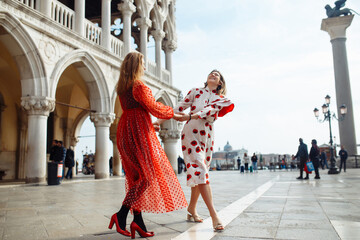 Obraz premium Mom and daughter in fashionable dresses walk around Venice. Lifestyle, travel, tourism.