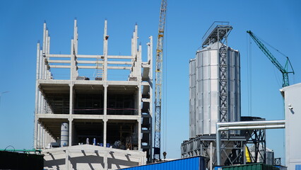 Structure building of steel structure roof truss frame installation by mobile crane under the construction building in the factory with blue sky. building structure.