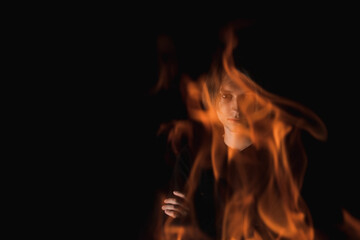 The view of an adult guy through the fire in complete darkness