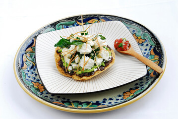 Mexican toast with beans, guacamole, pico de gallo and fresh cheese, typical Mexican food