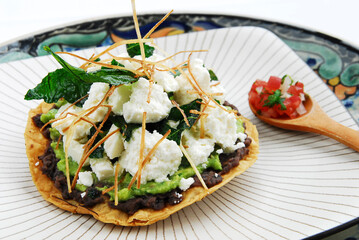 Mexican toast with beans, guacamole, pico de gallo and fresh cheese, typical Mexican food