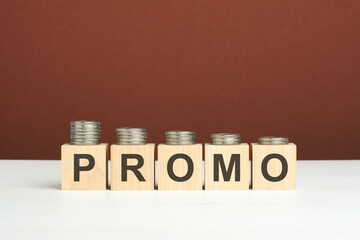 promo text on wooden blocks with coins on brown background