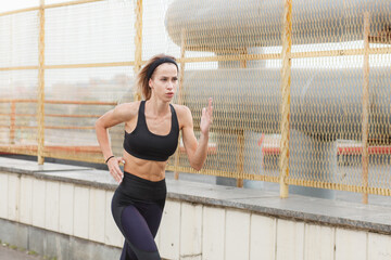 athletic fit woman running outdoor on urban street