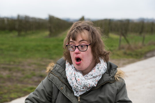 Hakendover, Flanders  Belgium -Portrait of white woman with Down Syndrome and myopia who looks at the other side with open mouth and surprised expression