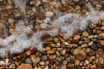 Pebble beach and sea foam