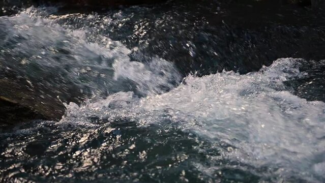Slow motion of Norwegian mountain river , stream flowing through rocks. Close up of river stones with flowing water, clean water flowing in a mountain river at the Norway